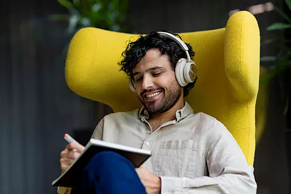 A man with headphones smiles